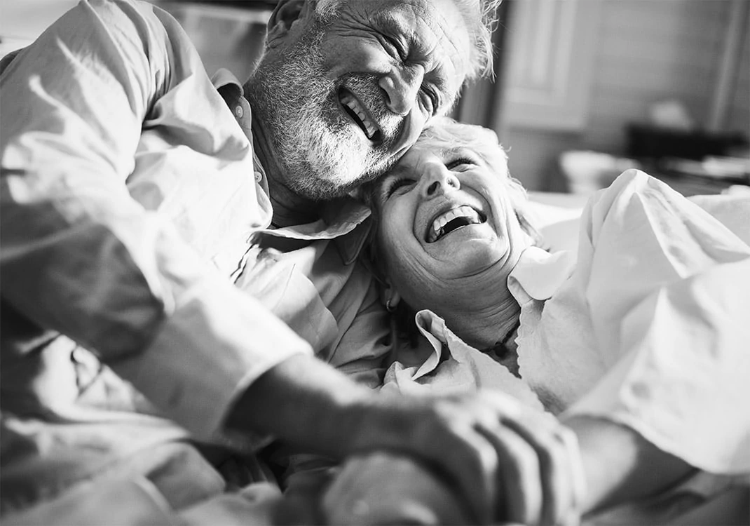 elderly couple holding hands and laughing