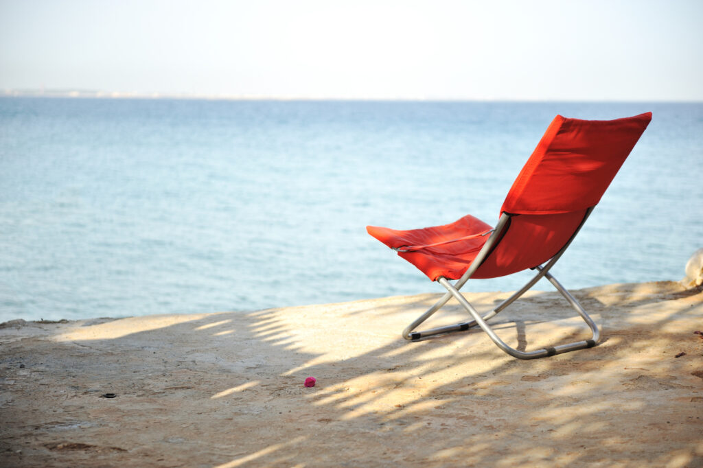 A red chair on a beach | Donating a timeshare