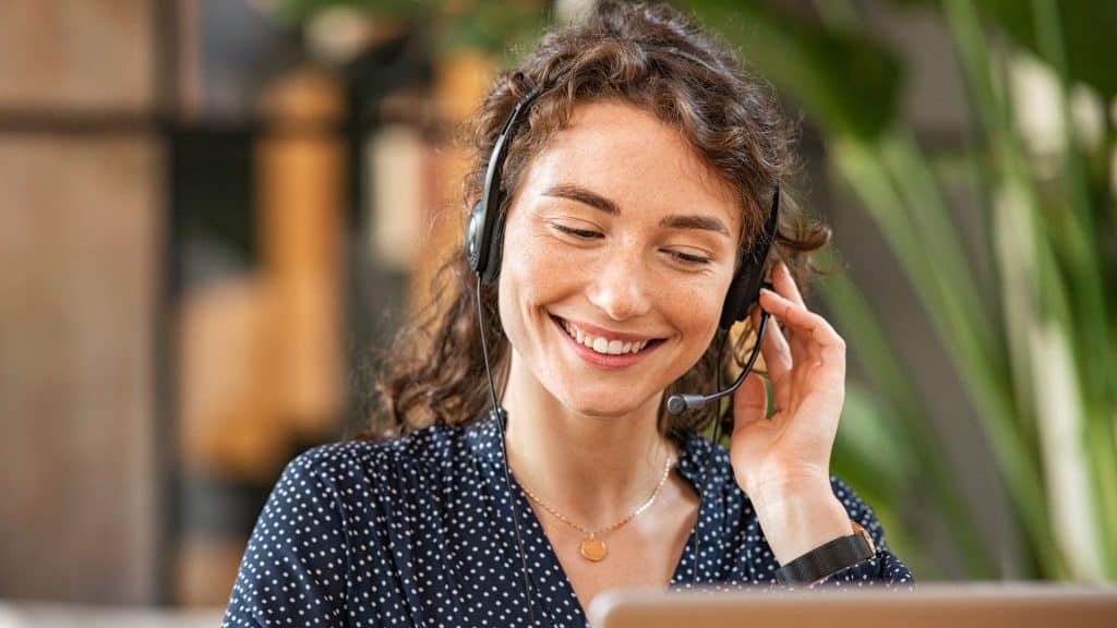 Timeshare cancellation agent smiles while talking to client using headset | Timeshare statistics and trends