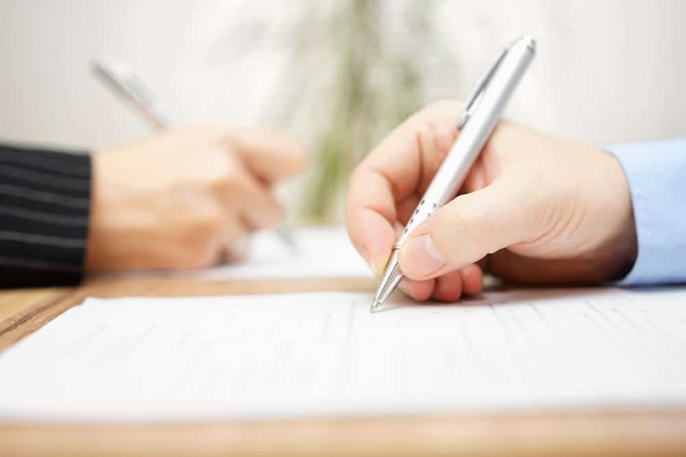 Two people signing an agreement on paper | Florida Timeshare Cancellation