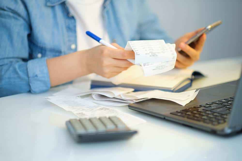 A woman calculating costs with receipts | South Carolina Timeshare Cancellation